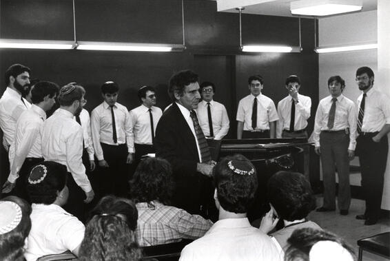 Imagen en blanco y negro de un grupo de hombres cantando juntos